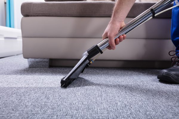 Janitor's Hand Cleaning Carpet With Vacuum Cleaner